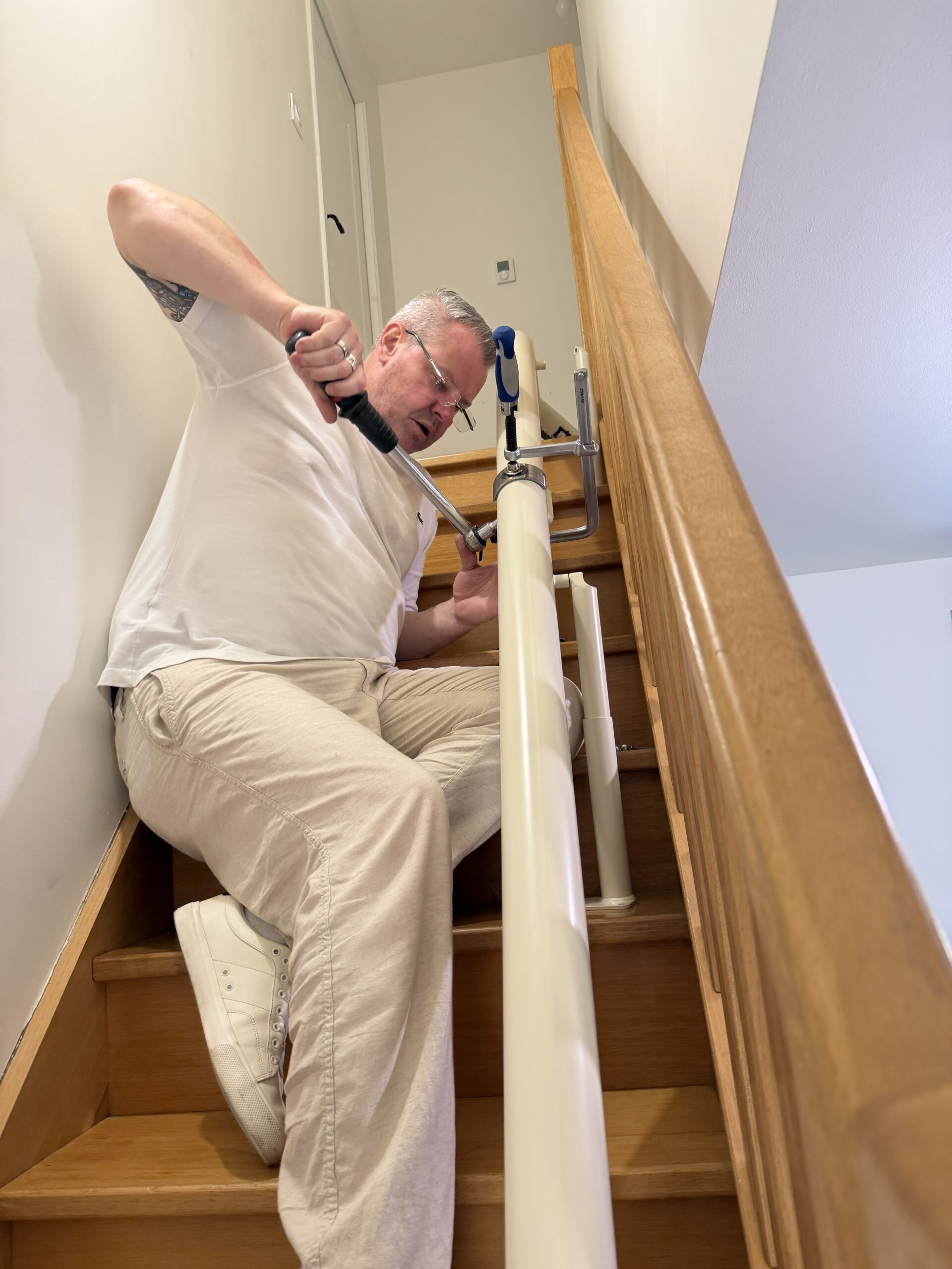 Technicien en train de régler un monte-escalier lors de la mise en service